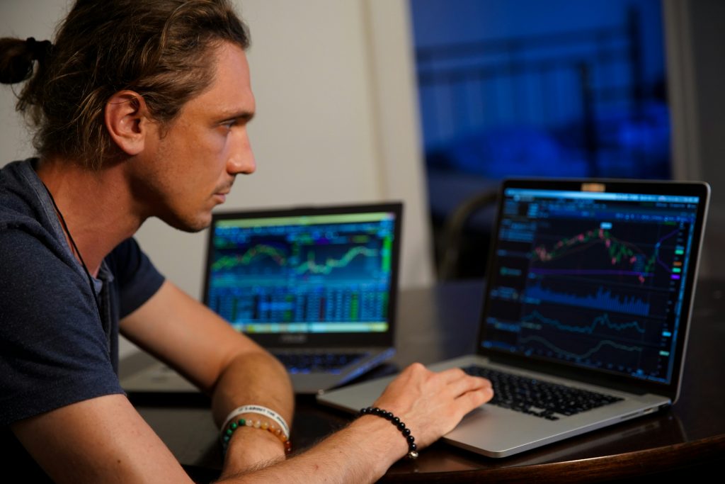 El hombre utiliza un ordenador portátil y analiza sus inversiones en bolsa.