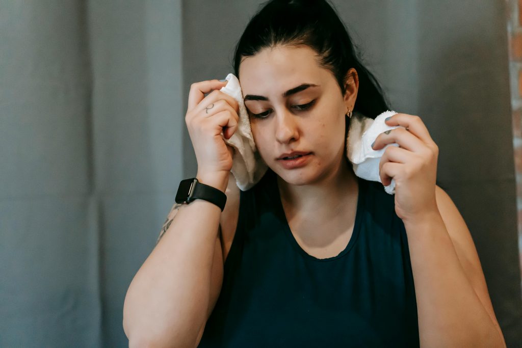 mujer limpiándose el sudor de la frente